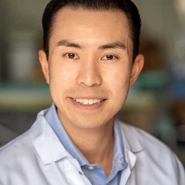 Dr. Kong, a dentist in Austin, in his office wearing his white coat.